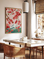 Illustrative cherry blossom branches with pink and red flowers framing snow-capped Mount Fuji, in a styled room mockup