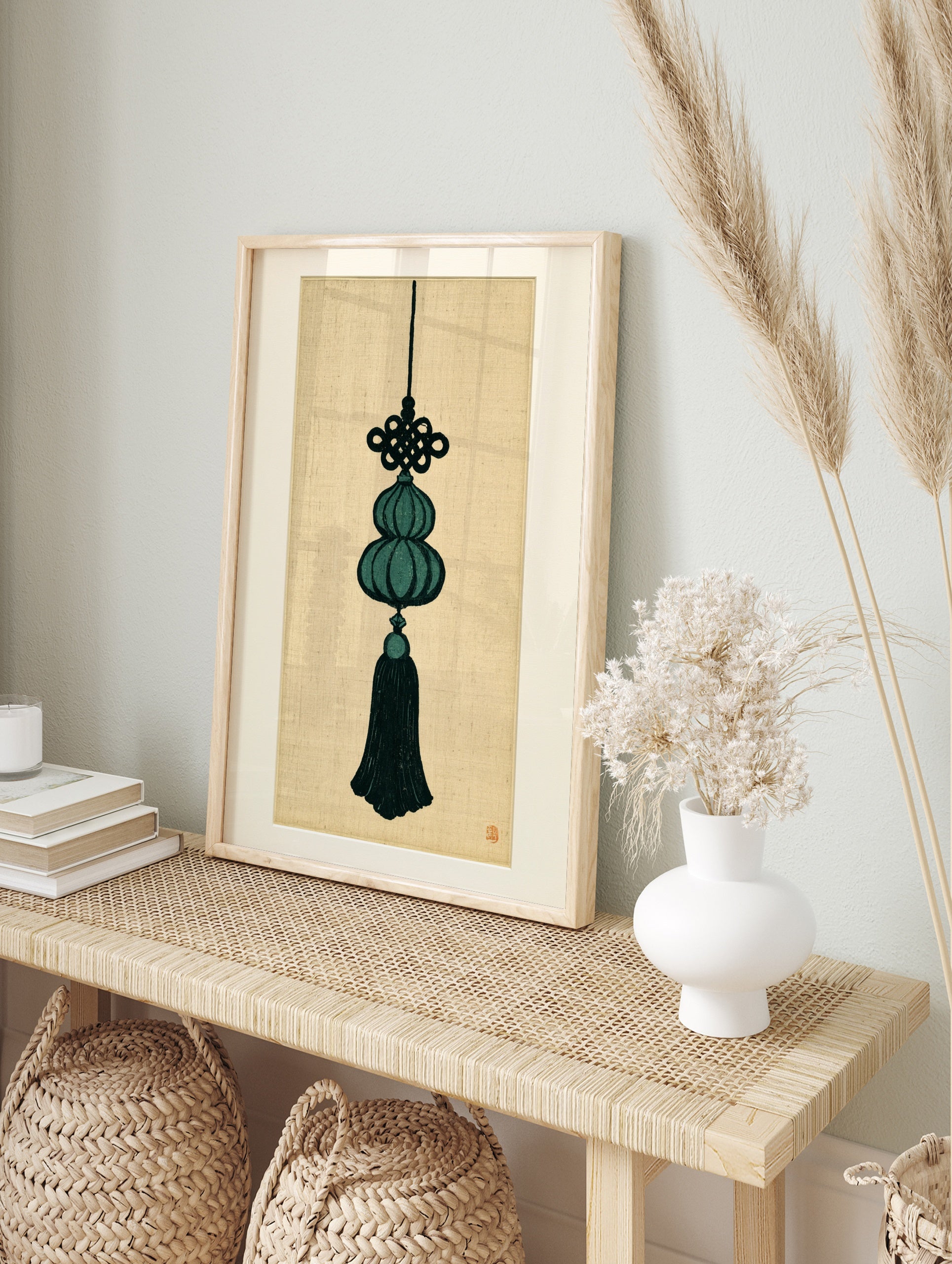 Decorative Chinese knot and gourd tassel illustration in deep teal and black on a beige, in an alternate framed mockup