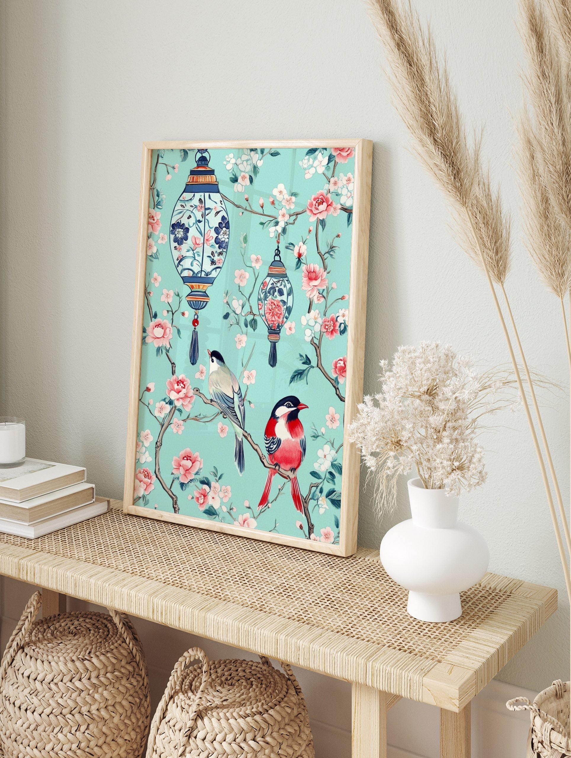 Chinoiserie art print with two colourful birds, pink blossoms, and blue lanterns on a teal, in an alternate framed mockup