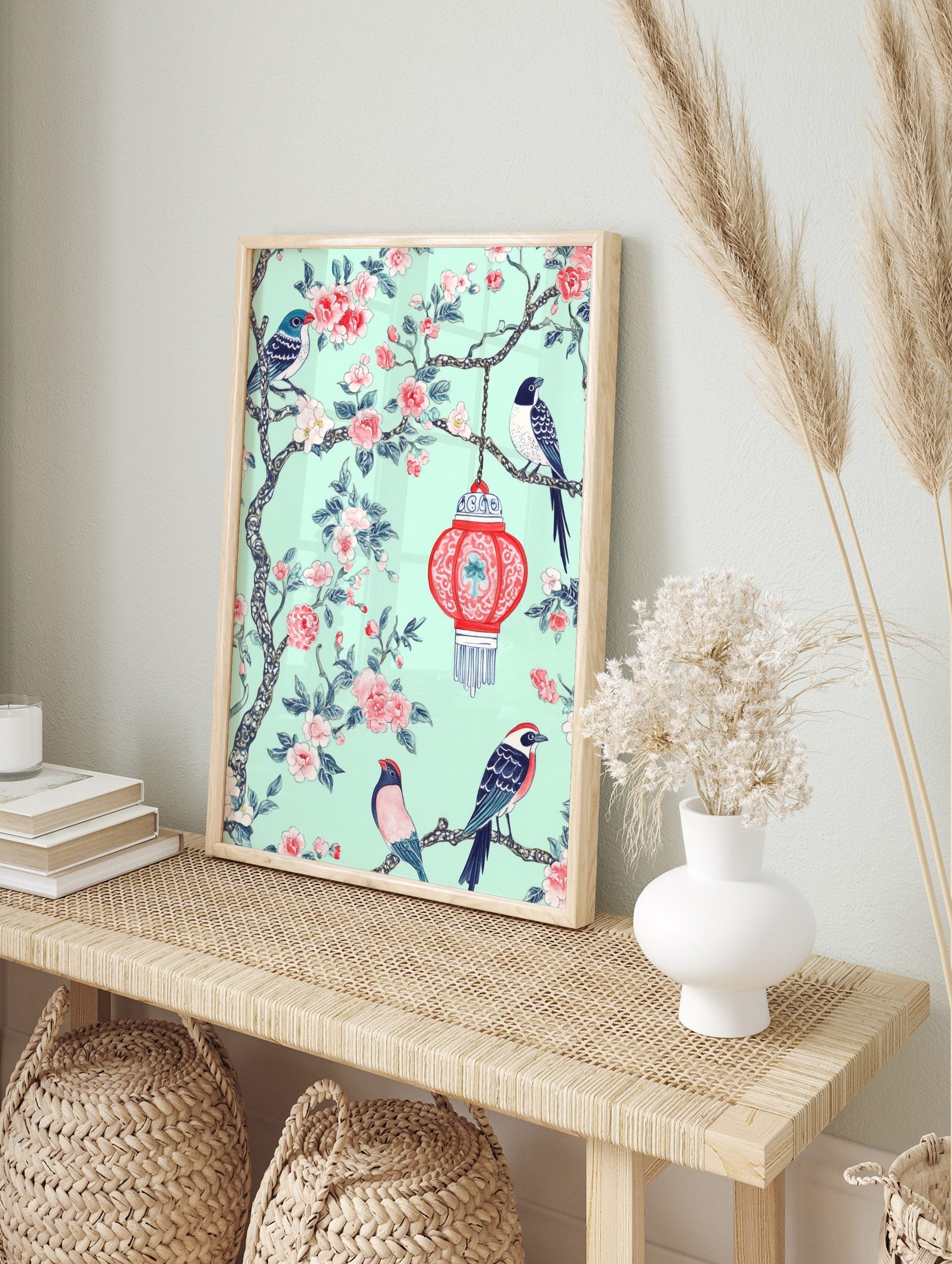Chinoiserie wall art with three birds, pink flowers, and a red lantern on a mint green, in an alternate framed mockup