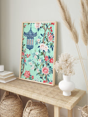 Chinoiserie style art print with blue pagoda lantern, pink and white flowers, green leaves on, in an alternate framed mockup