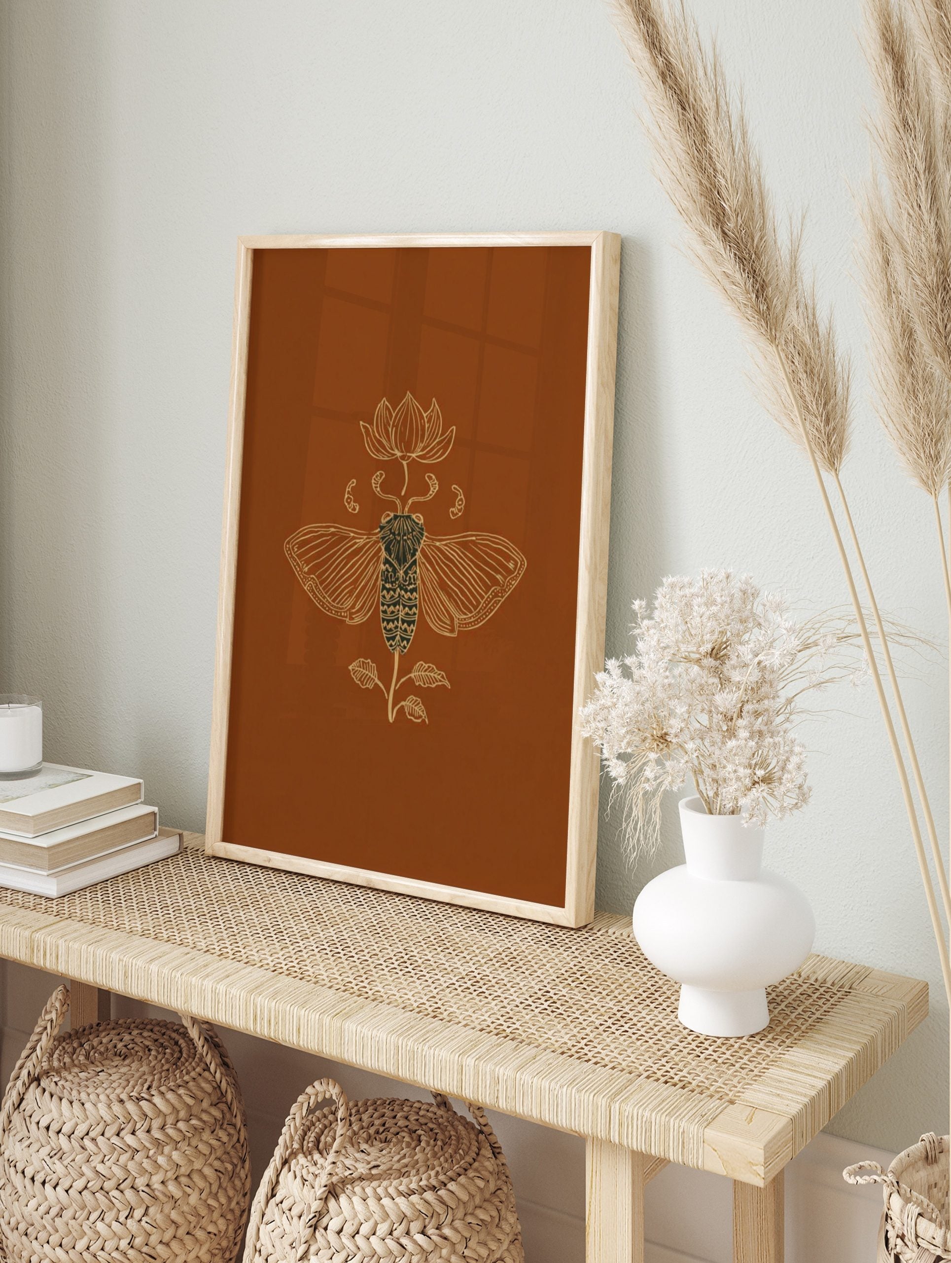 Ornate golden line art illustration of a cicada and lotus flower on a rich brown background, in an alternate framed mockup