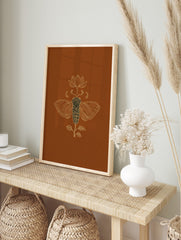 Ornate golden line art illustration of a cicada and lotus flower on a rich brown background, in an alternate framed mockup
