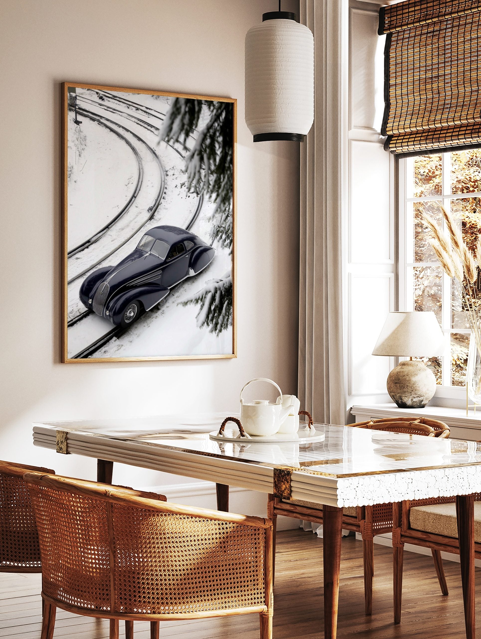 Navy blue classic car on snow-covered train tracks, high-angle view with pine branches and curving, in a styled room mockup