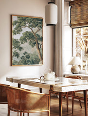 Classic illustrative tree landscape print with dense green foliage, brown trunks, and hazy mountains, in a styled room mockup