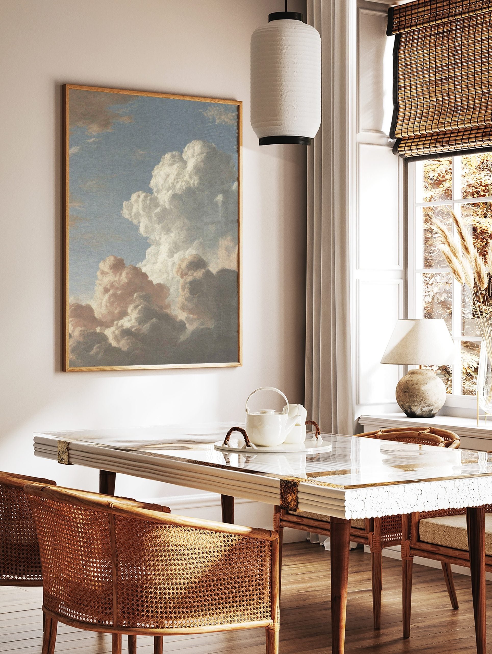 Dramatic cloud study painting with voluminous white and grey clouds against a soft blue sky, in a styled room mockup