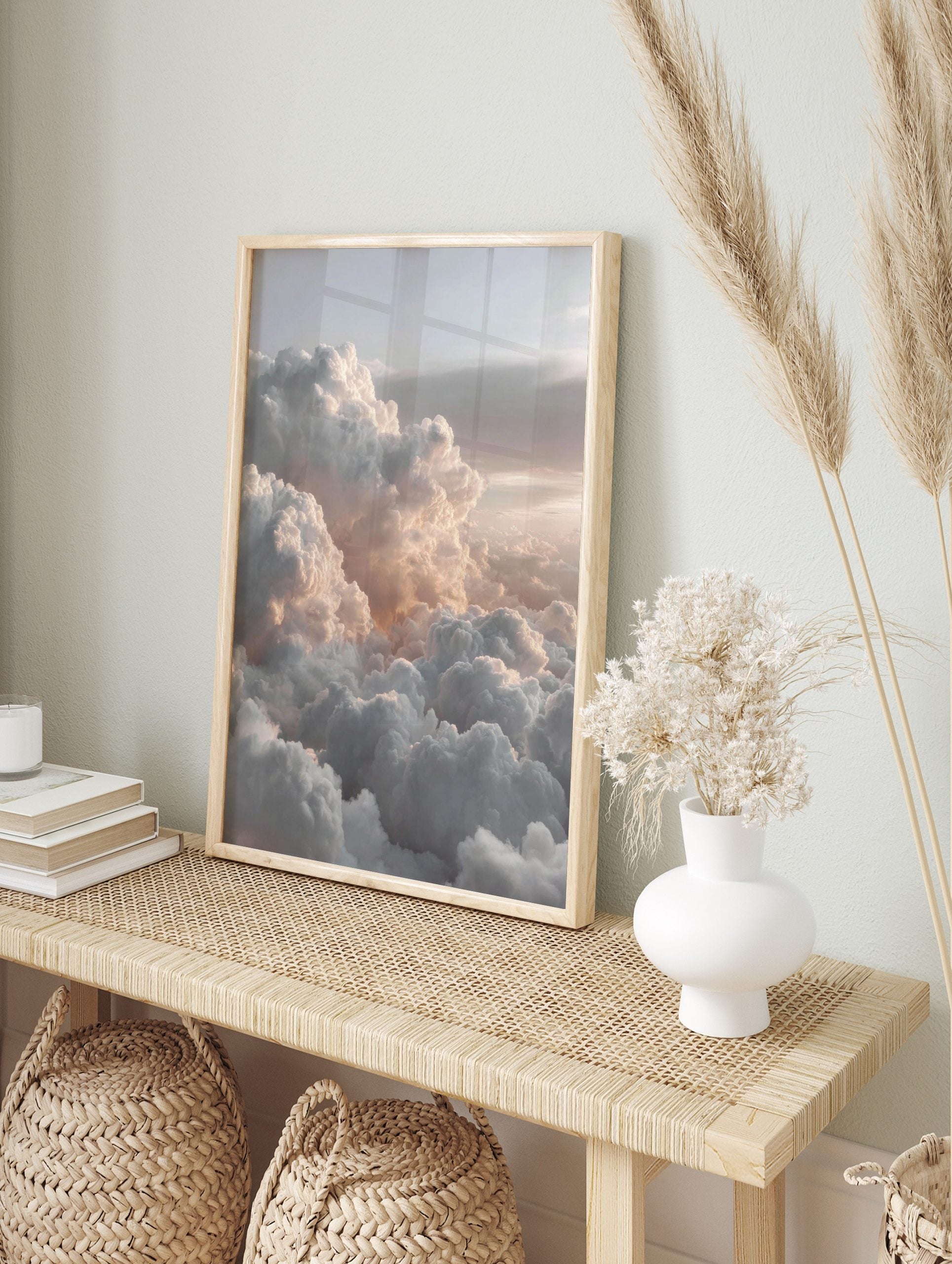 Aerial view of fluffy white and grey clouds with soft peachy light across a vast sky, in an alternate framed mockup