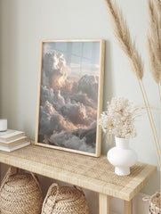 Majestic cumulus clouds with warm light over mountain peaks in a serene cloudscape wall art, in an alternate framed mockup