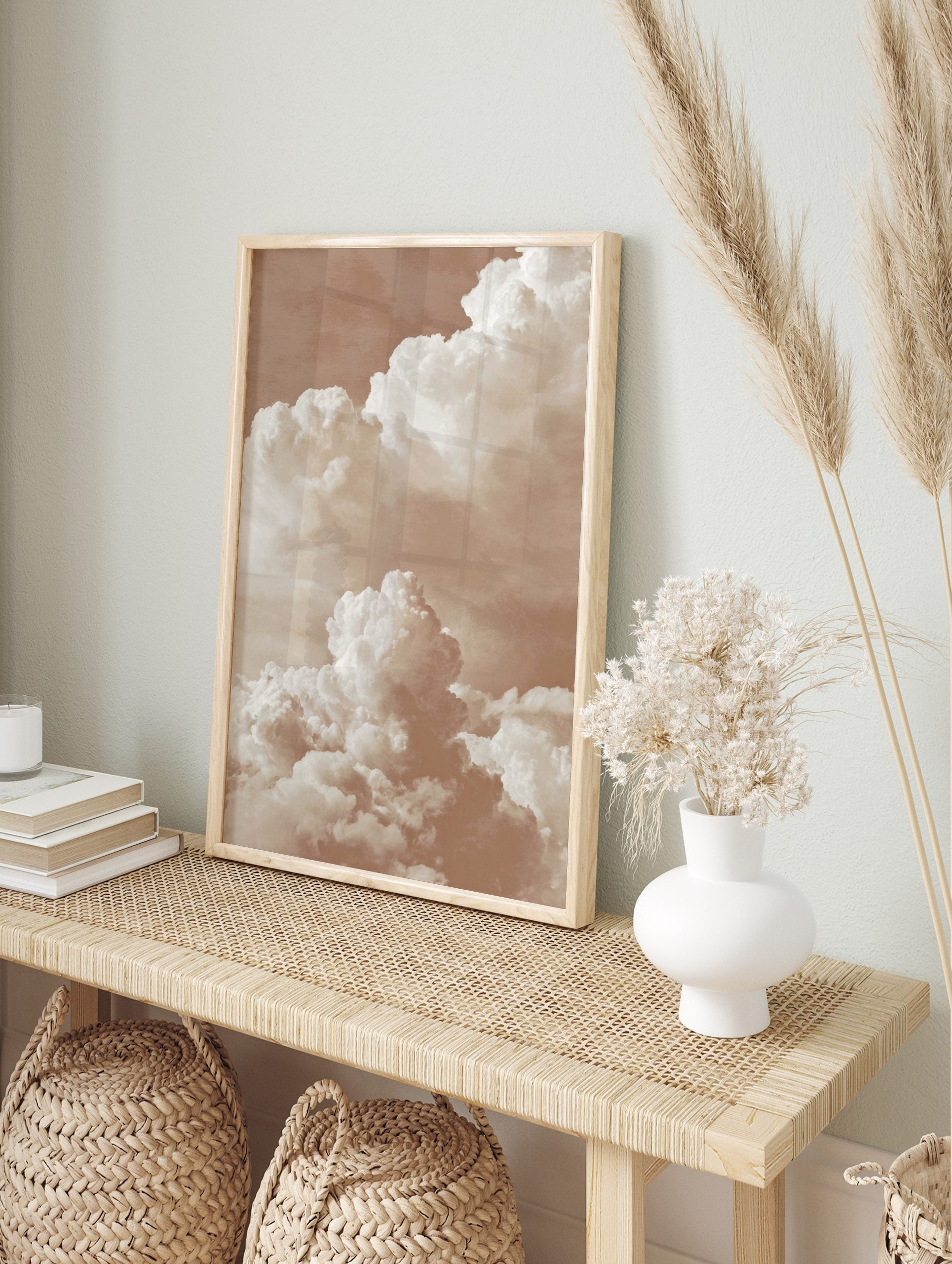 Warm sepia-toned photographic print of large, layered cumulus clouds against a soft sky, in an alternate framed mockup