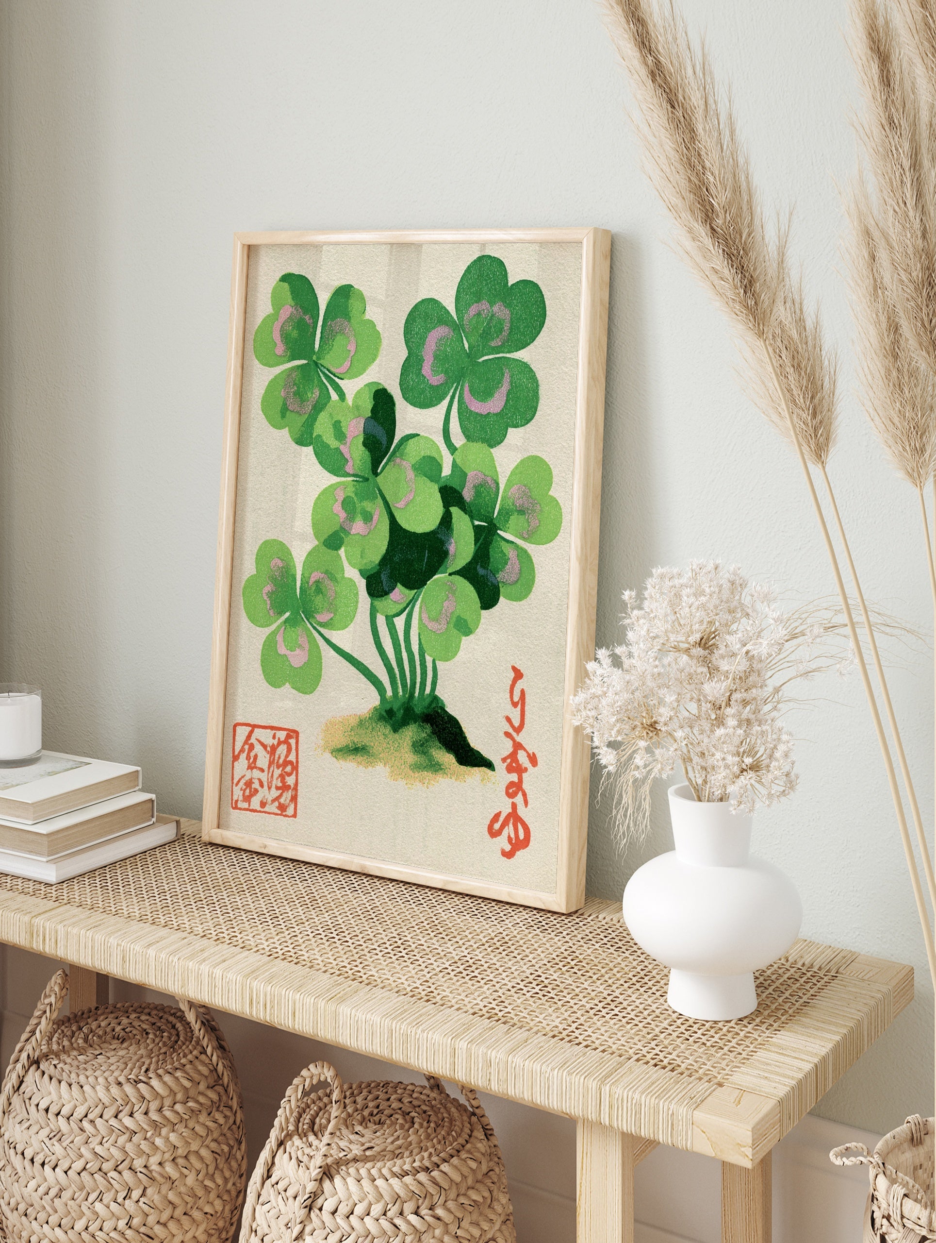 Clover botanical illustration with green leaves and pink accents, Japanese calligraphy, and, in an alternate framed mockup