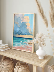 Colourful painterly beach scene art print with blue and peach clouds, turquoise ocean, and, in an alternate framed mockup