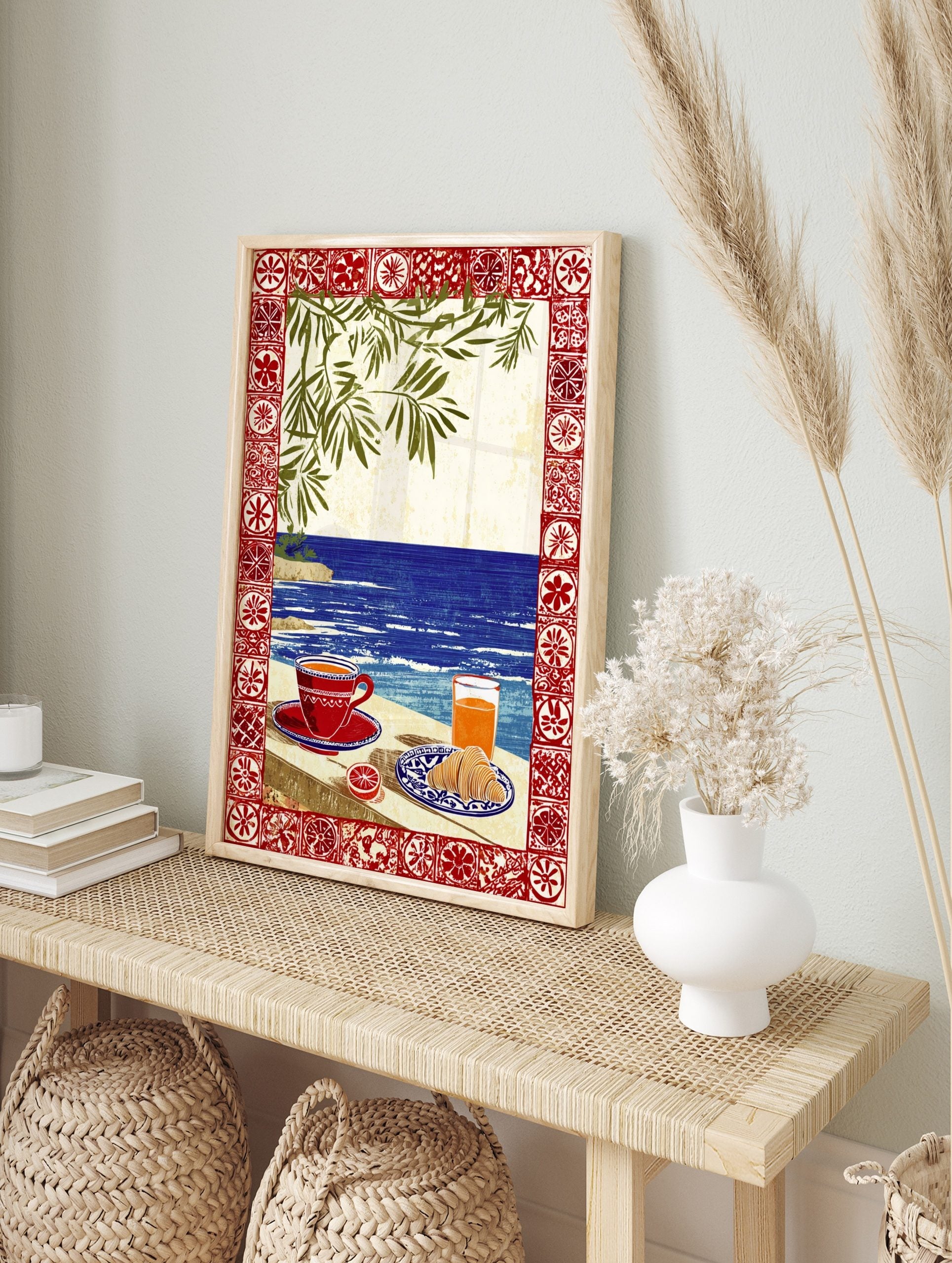 Illustrative coastal breakfast scene with coffee, croissant, orange juice, blue sea, green, in an alternate framed mockup