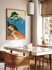 Coastal cottage wall art with red roof house, pine tree, and sailboat on blue sea landscape, in a styled room mockup