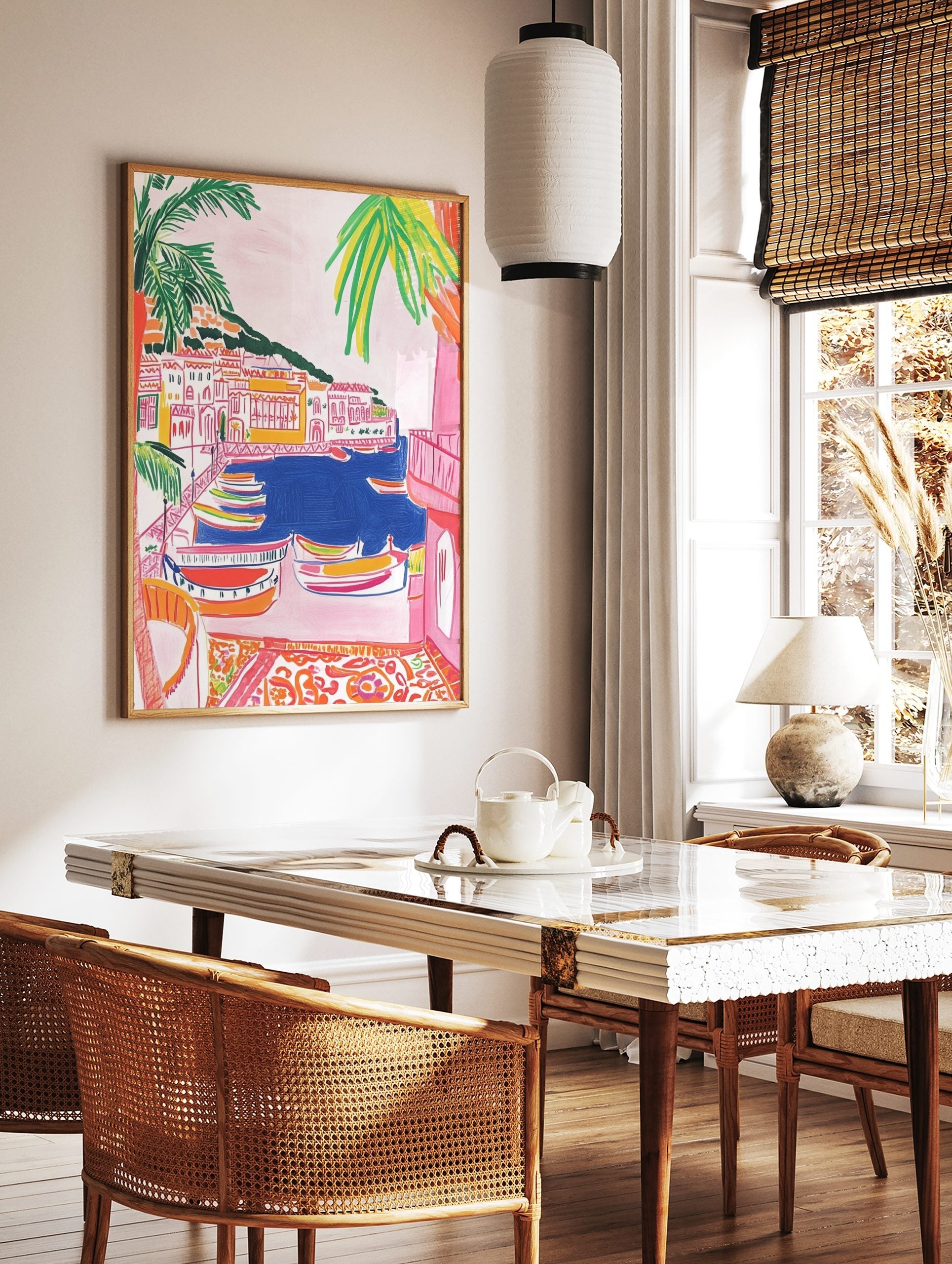 Colourful illustrative wall art of a coastal village with boats in a blue harbour and palm trees, in a styled room mockup