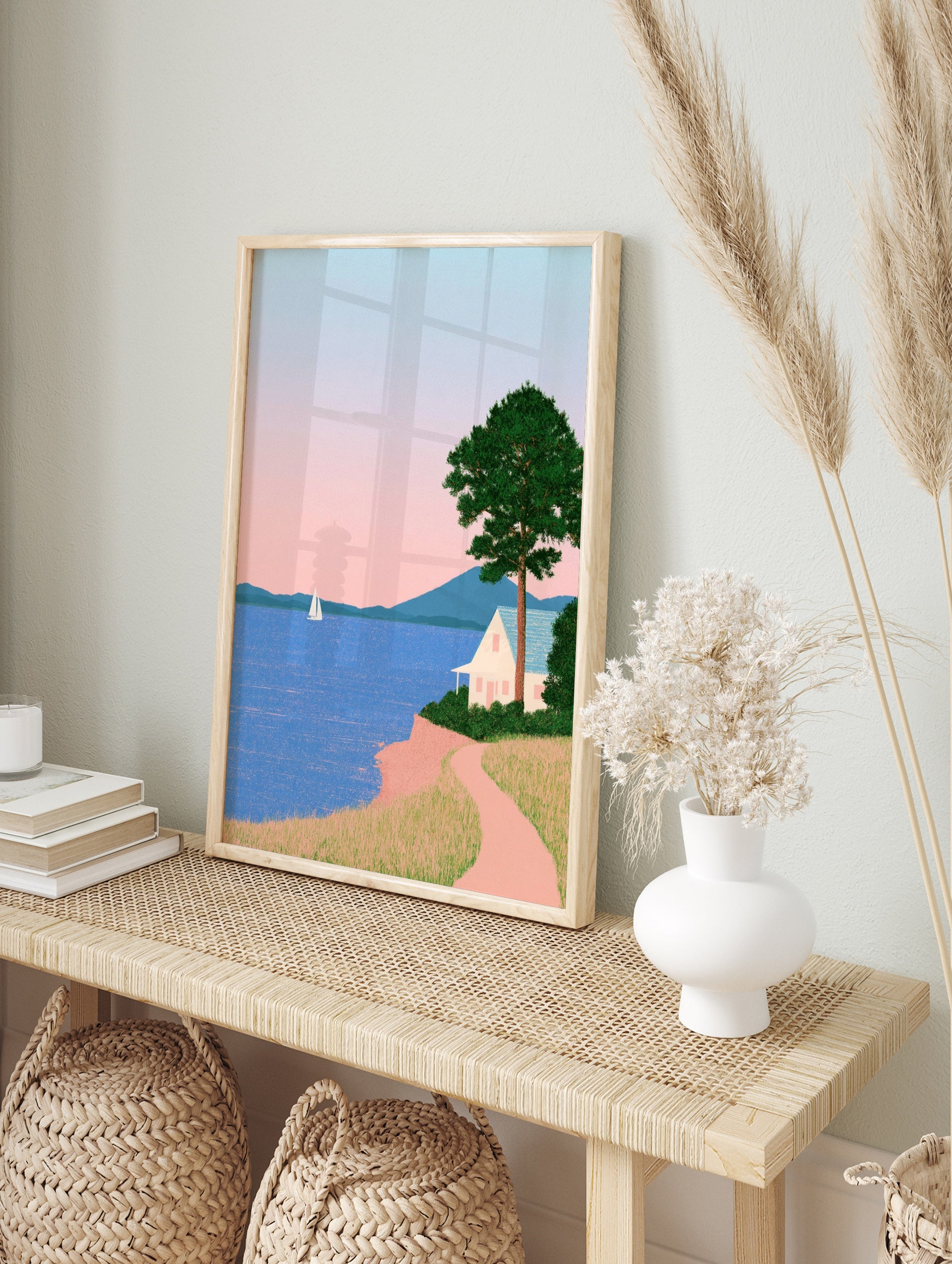 Minimalist coastal landscape art print featuring a white house on a cliff, a sailboat, in an alternate framed mockup