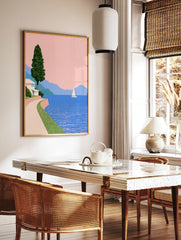 Minimalist coastal wall art featuring a white house, winding path, sailboat, and blue mountains, in a styled room mockup