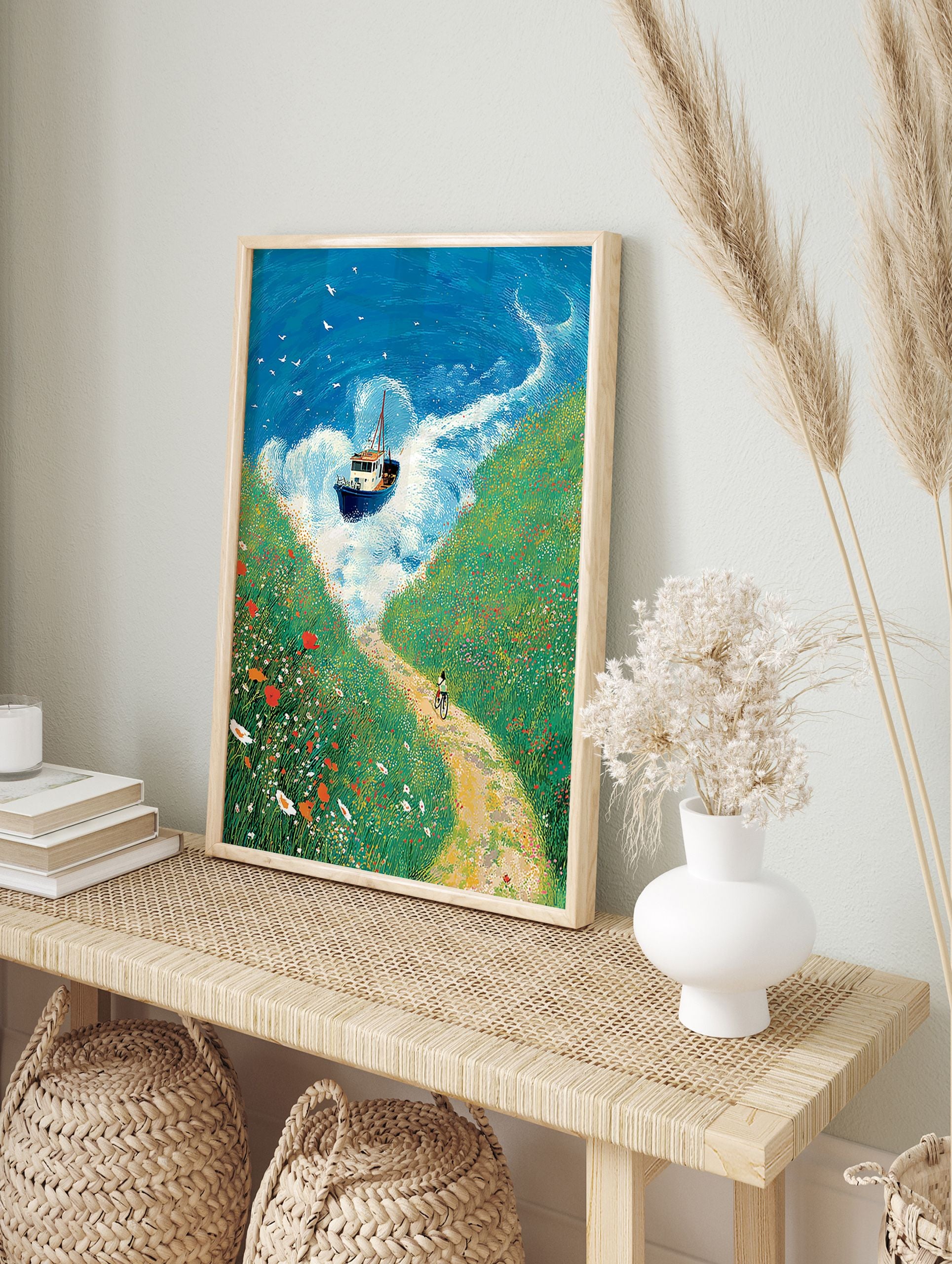 Illustrated coastal landscape wall art with a boat on blue waves, green wildflower cliffs, and a person cycling on a dirt path. - Image 3