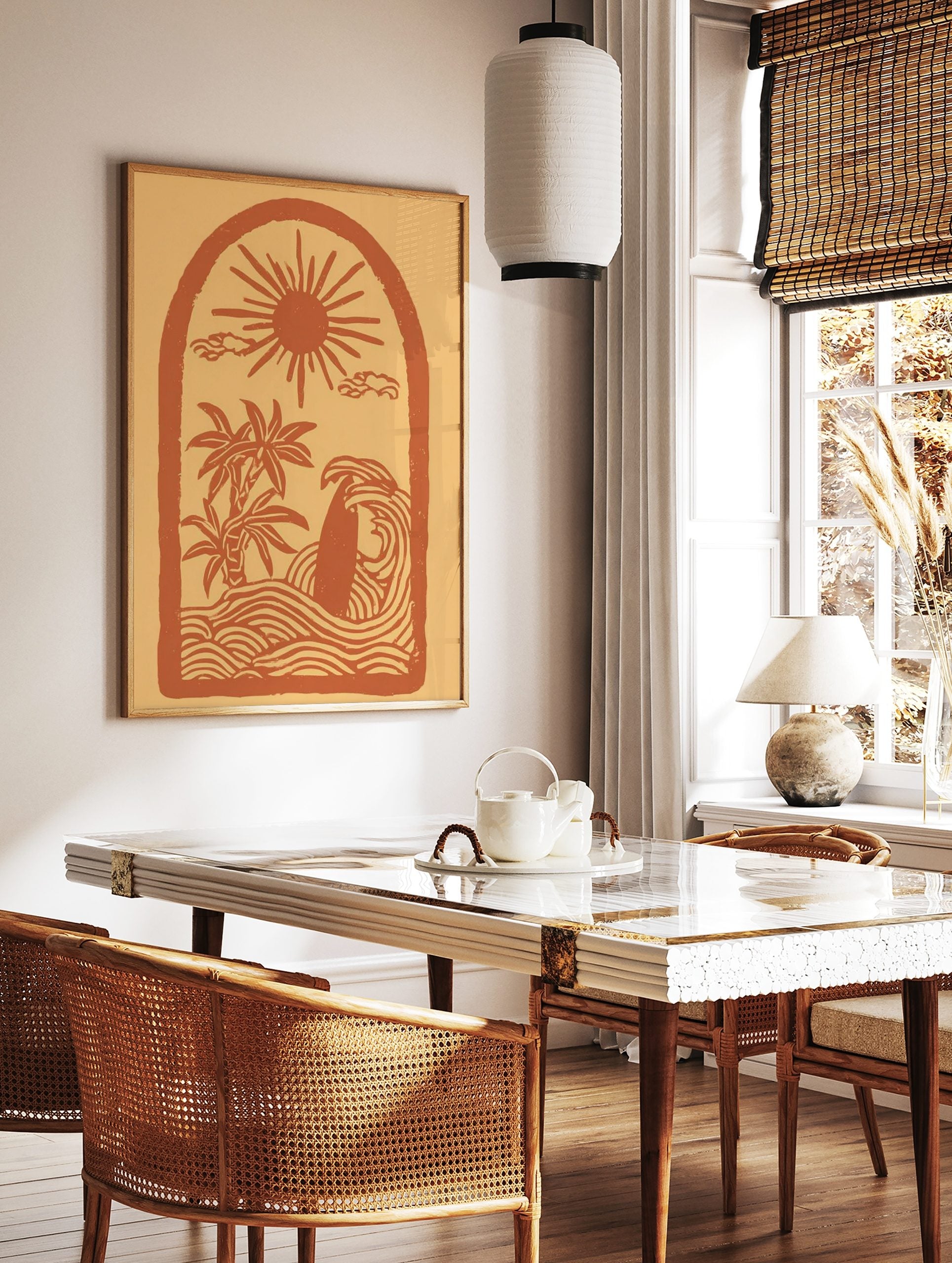 Illustrative coastal scene art print with sun, palm trees, surfboard in waves, within an arch frame, in a styled room mockup
