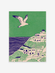Illustrative coastal wall art print showing a white village on green hills, blue sea, and a flying seagull.