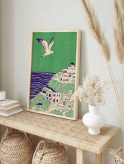 Illustrative coastal wall art print showing a white village on green hills, blue sea, and a flying seagull. - Image 3