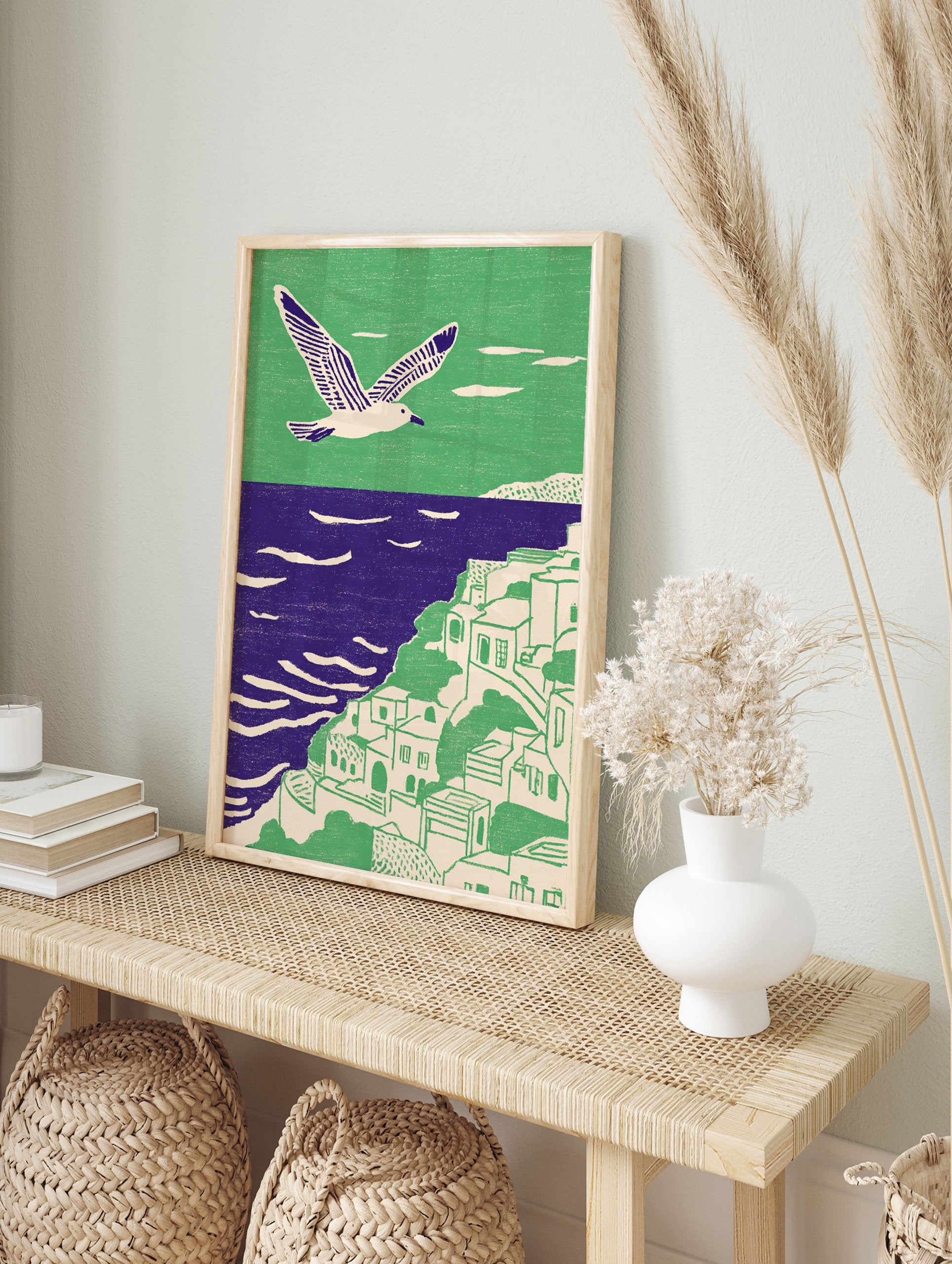 Illustrative coastal wall art with a white seagull flying over a green cliffside village and purple ocean. - Image 3
