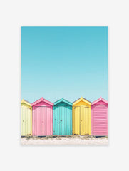 Colorful beach huts poster in yellow, pink, and teal on a sandy beach under a bright blue sky, coastal photography.