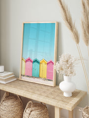Colorful beach huts poster in yellow, pink, and teal on a sandy beach under a bright blue sky, coastal photography. - Image 4