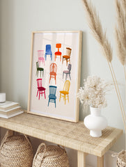 Illustration of nine colourful chairs in various styles arranged in a circle on a neutral, in an alternate framed mockup
