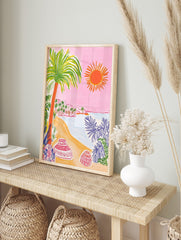Colourful illustrative beach scene with palm tree, orange sun, sandy shore, ocean, and, in an alternate framed mockup