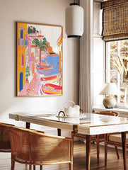 Colourful illustrative coastal village art print with yellow buildings, palm tree, and striped, in a styled room mockup