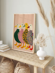 Four colourful illustrative ducks in green, pink, leopard, and multi-patterned bodies on a, in an alternate framed mockup