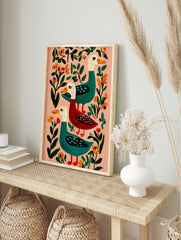 Illustrative folk art print of three colourful ducks, two teal and one red, with orange, in an alternate framed mockup