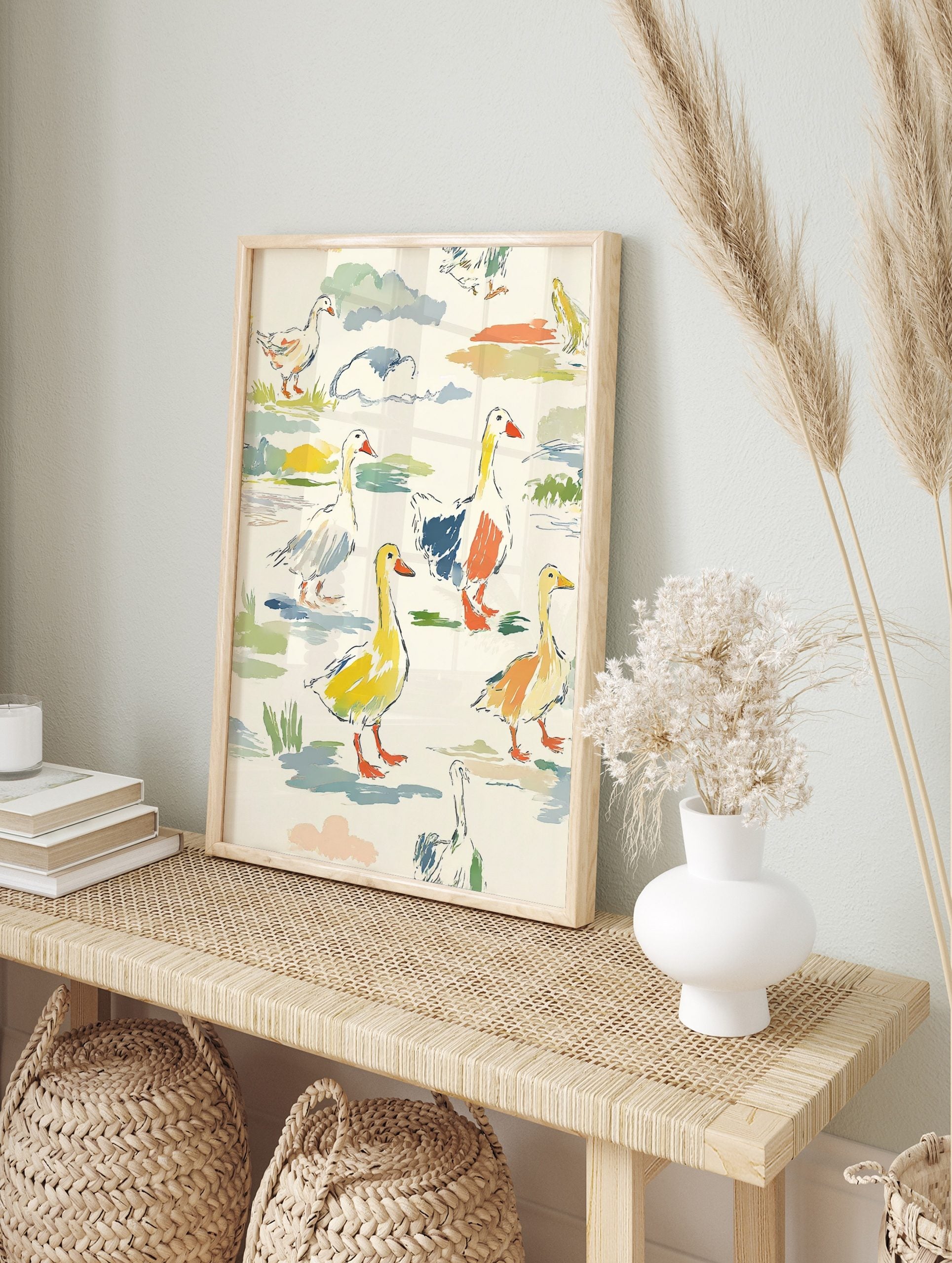 Colourful illustrative print of geese and goslings in a multi-colour landscape with, in an alternate framed mockup