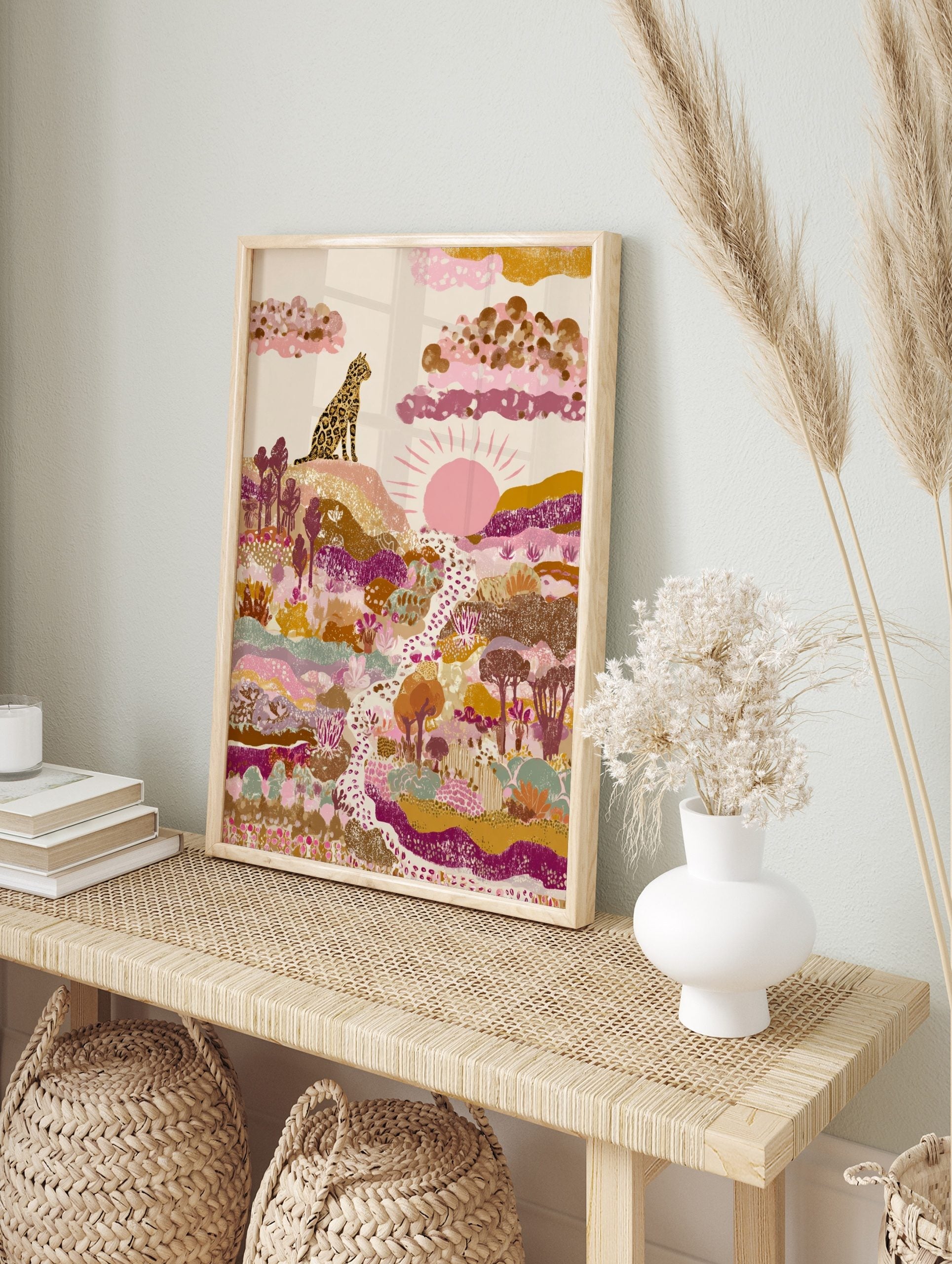 Illustrative leopard sitting on hill, overlooking a colourful abstract landscape with sun, in an alternate framed mockup