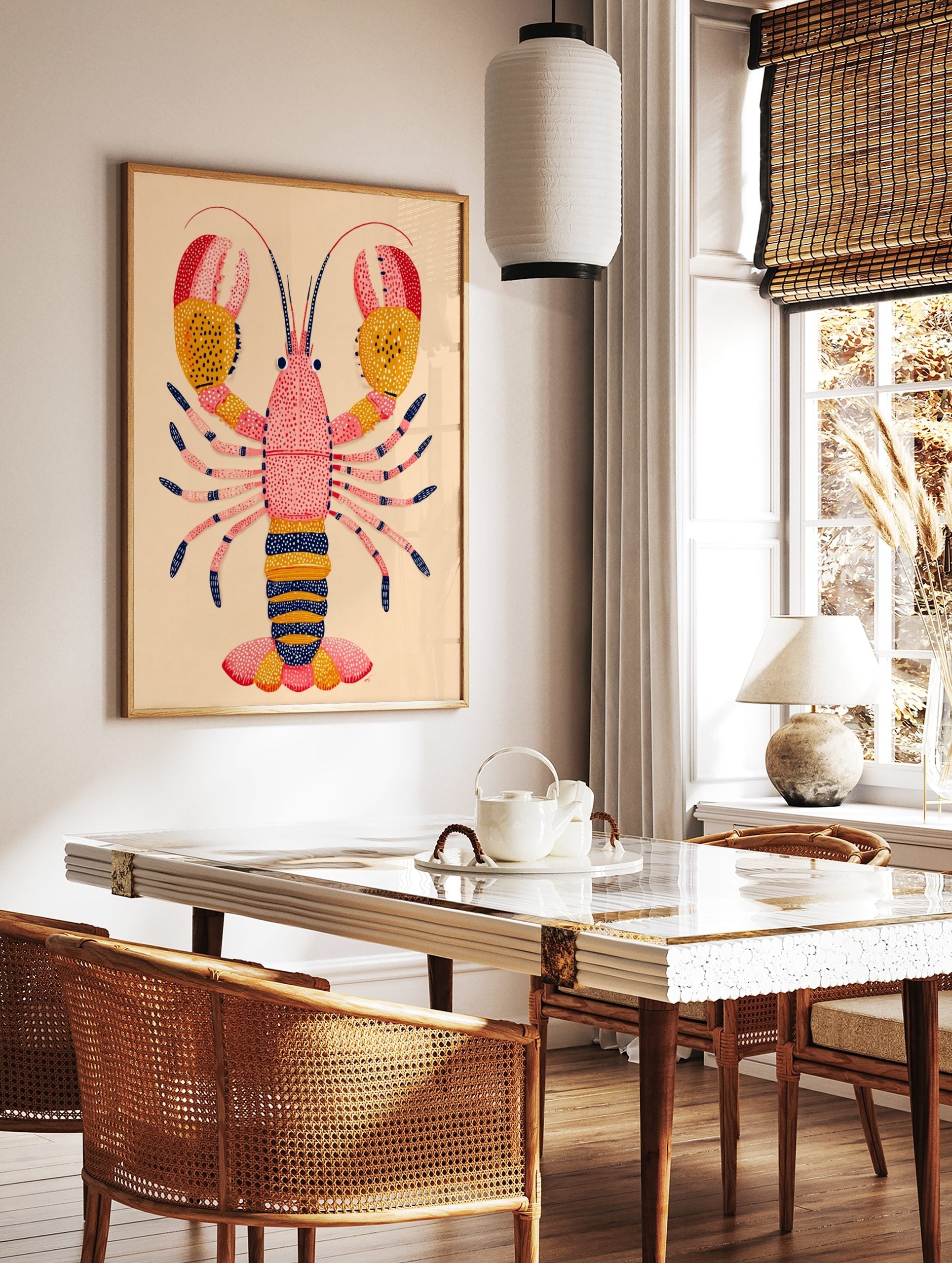 Illustrative lobster art print with pink body, yellow and red dotted claws, and navy accents on a, in a styled room mockup
