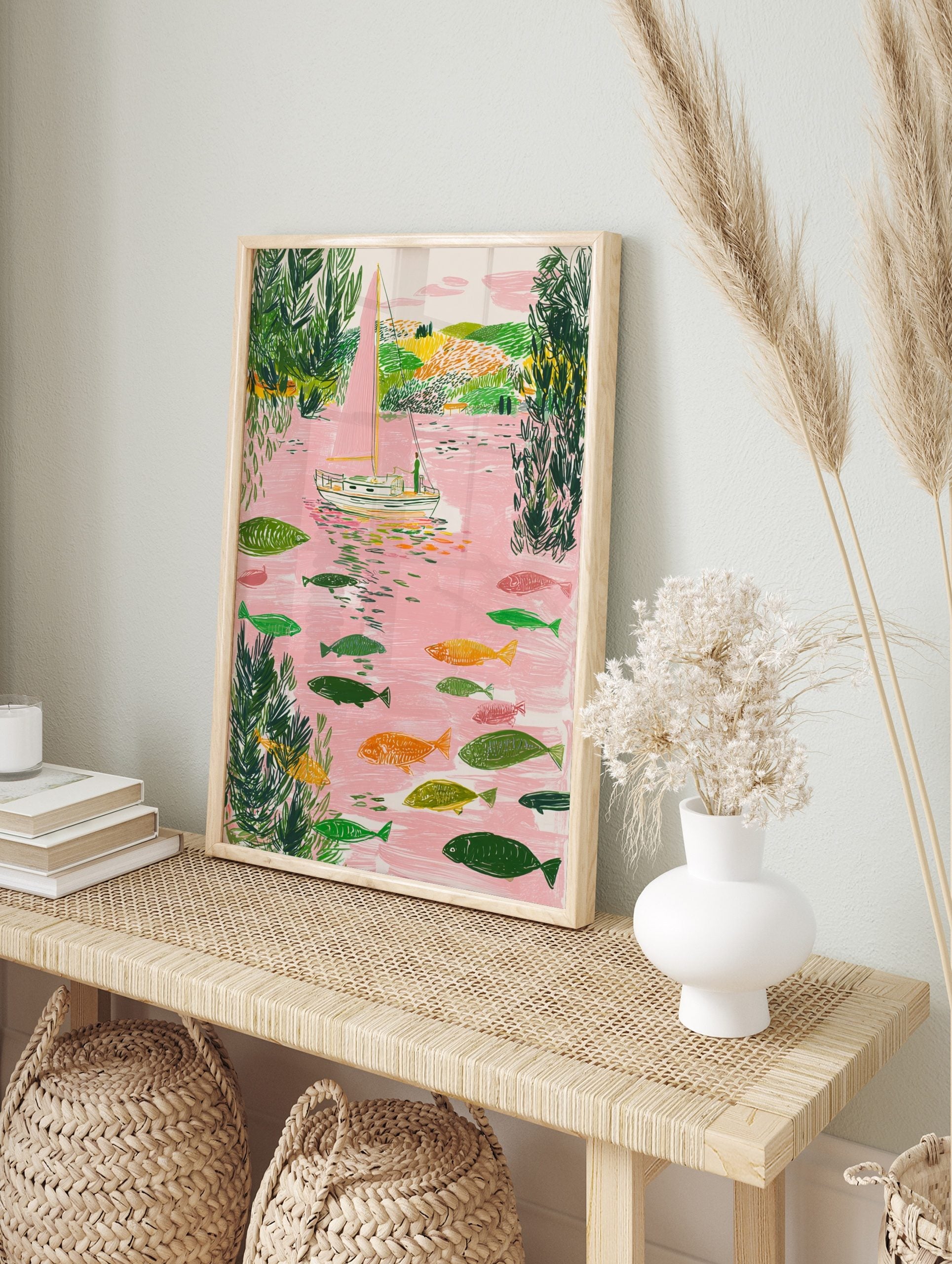 Illustrative sailboat with pink sail and many fish in a pink river with green foliage, in an alternate framed mockup