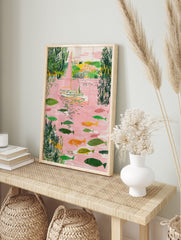 Illustrative sailboat with pink sail and many fish in a pink river with green foliage, in an alternate framed mockup