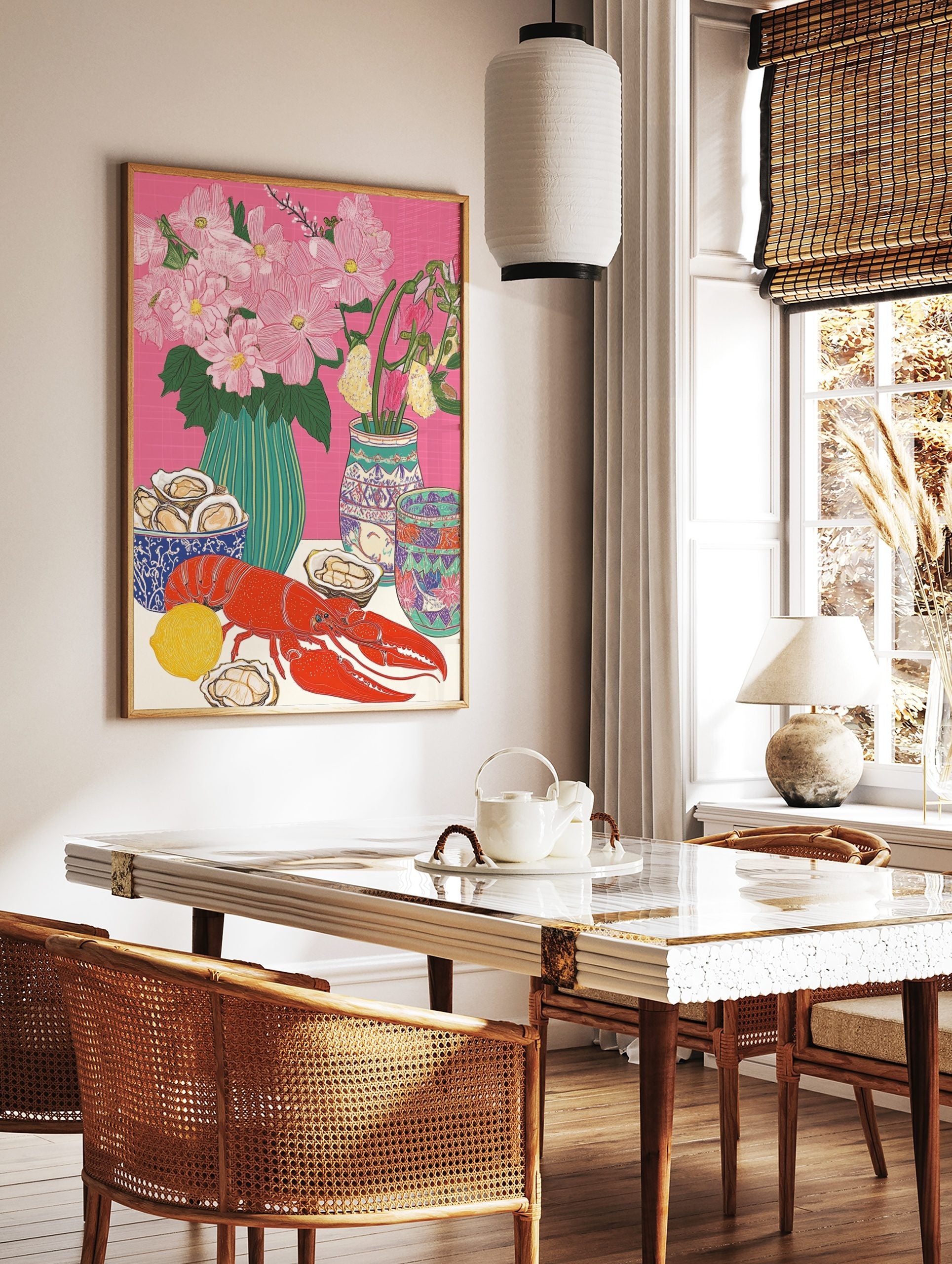 Illustrative still life print of a red lobster, oysters, lemon, and pink flowers in vases on a pink, in a styled room mockup
