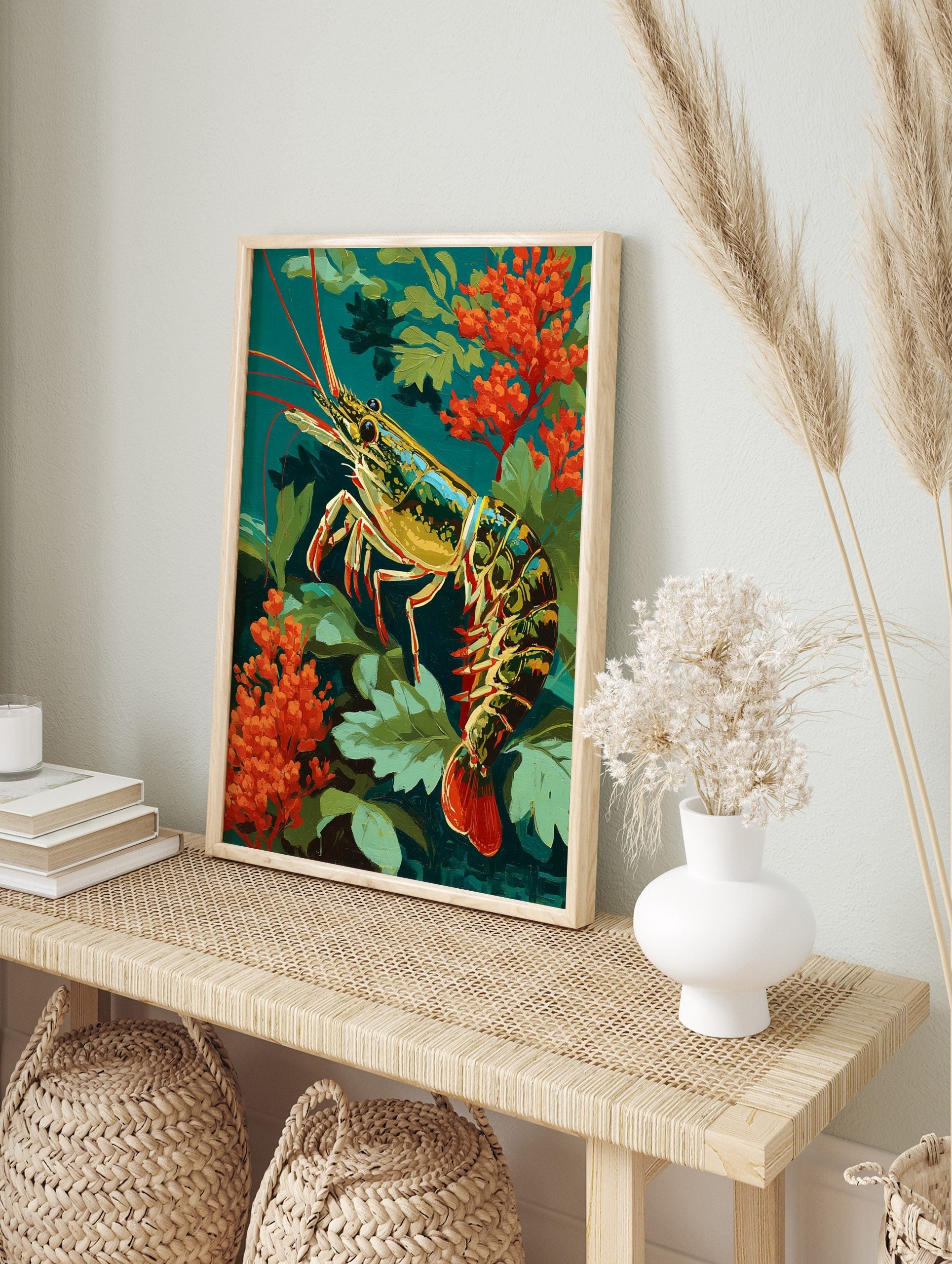 Colourful illustrative shrimp with red antennae and tail, amidst green leaves and orange, in an alternate framed mockup