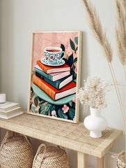 Illustrative art print of a floral teacup on a stack of books, surrounded by green leaves and, in an alternate framed mockup