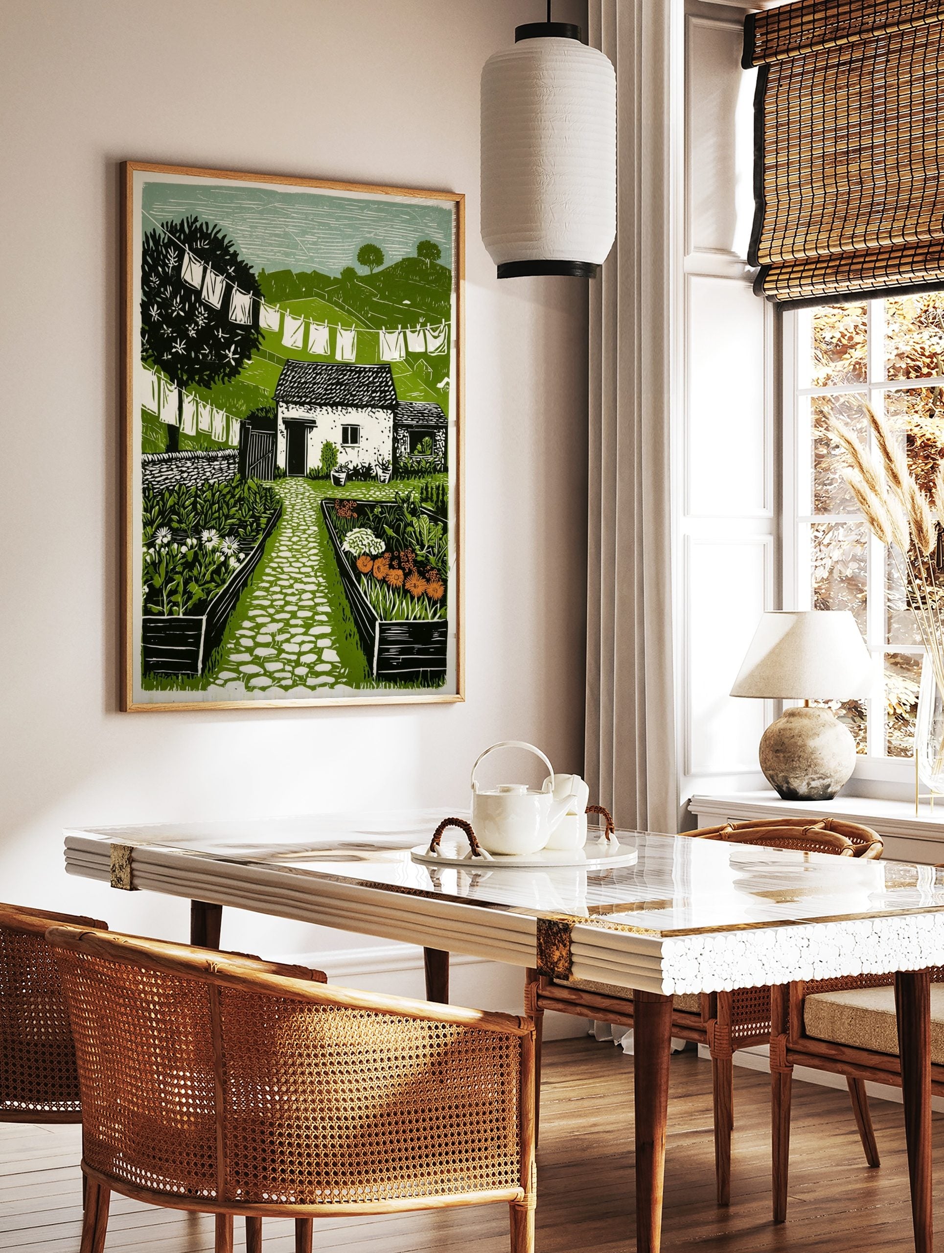Linocut illustration of a cottage garden with a stone path, white laundry on lines, and green hills, in a styled room mockup
