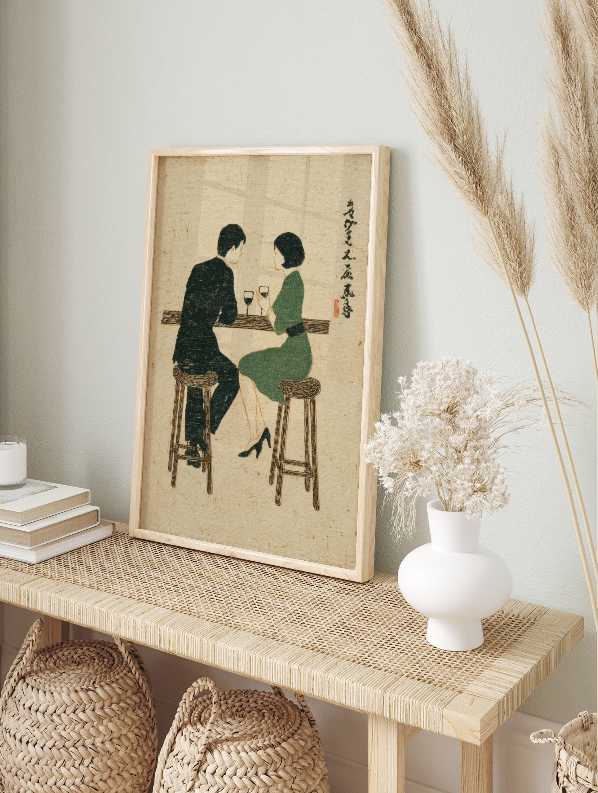 Illustrative print of a man and woman at a bar with wine, in a mid-century modern style with, in an alternate framed mockup