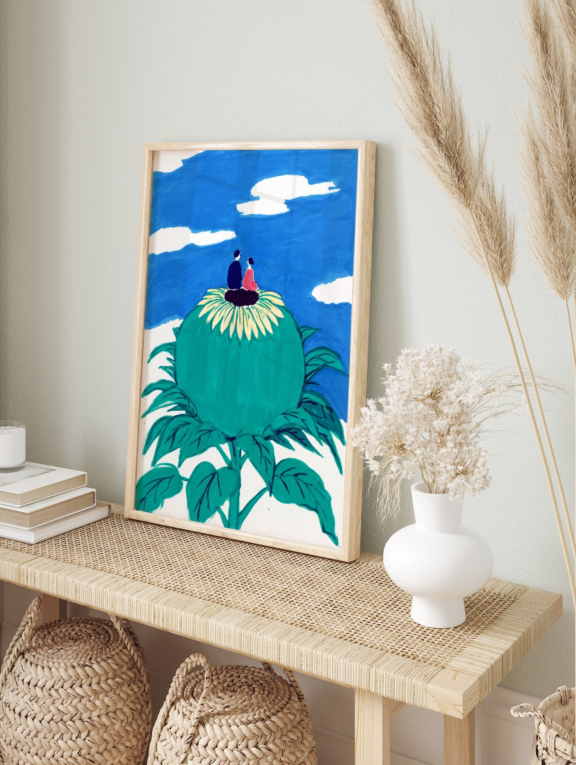 Illustrative art print of a couple on a giant green flower looking at a blue sky with white, in an alternate framed mockup
