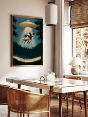 Surreal cow abduction wall art print featuring a UFO in a silhouetted forest with a glowing, in a styled room mockup