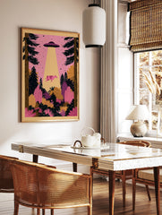 Illustrative pink cow being abducted by a UFO in a forest with pine trees and pink sky, in a styled room mockup