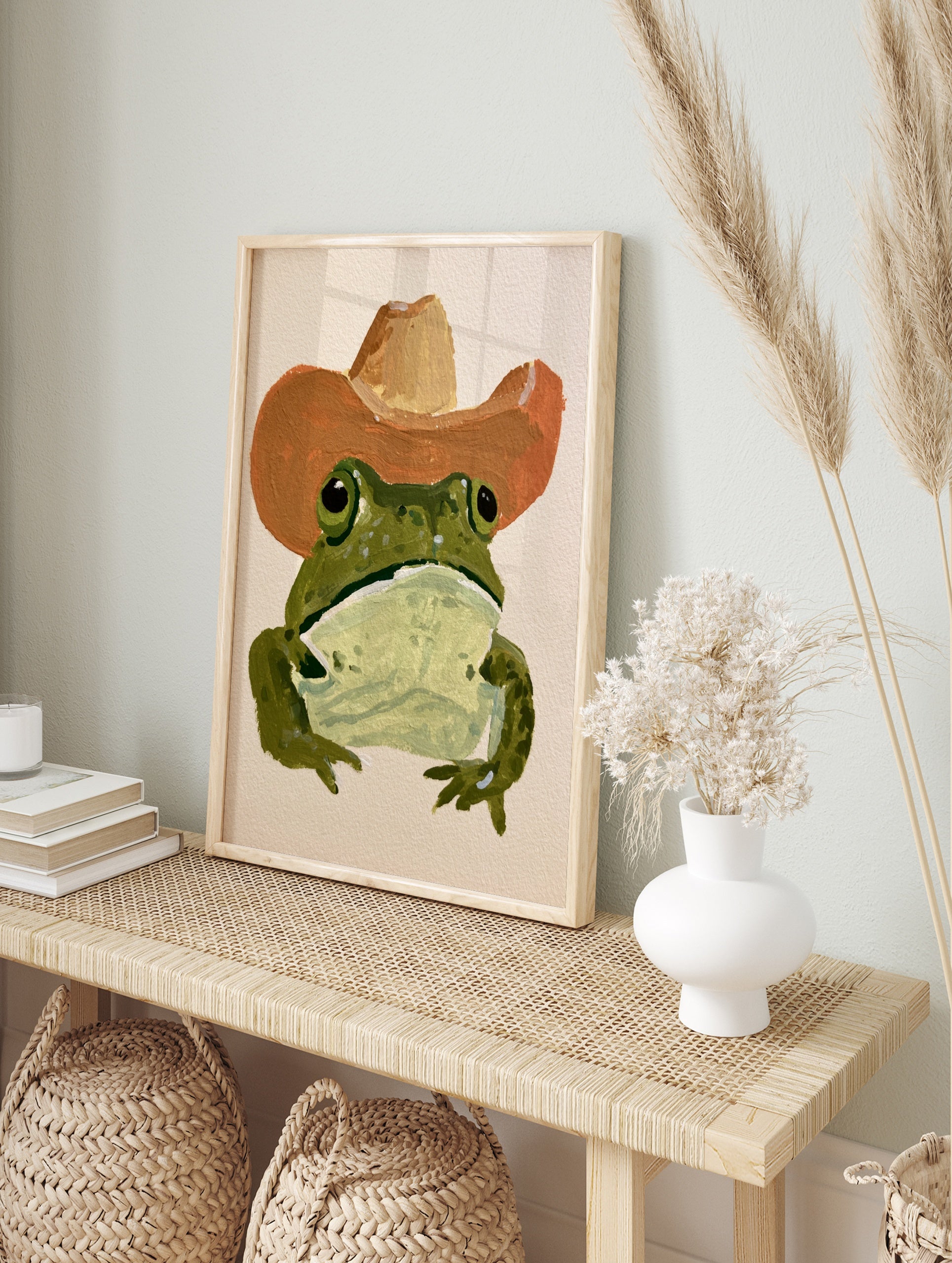 Green frog wearing a brown cowboy hat in a painterly illustrative style art print, in an alternate framed mockup