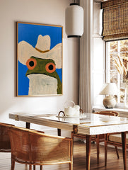 Illustration of a frog wearing a cowboy hat against a bright blue background, art print on satin, in a styled room mockup