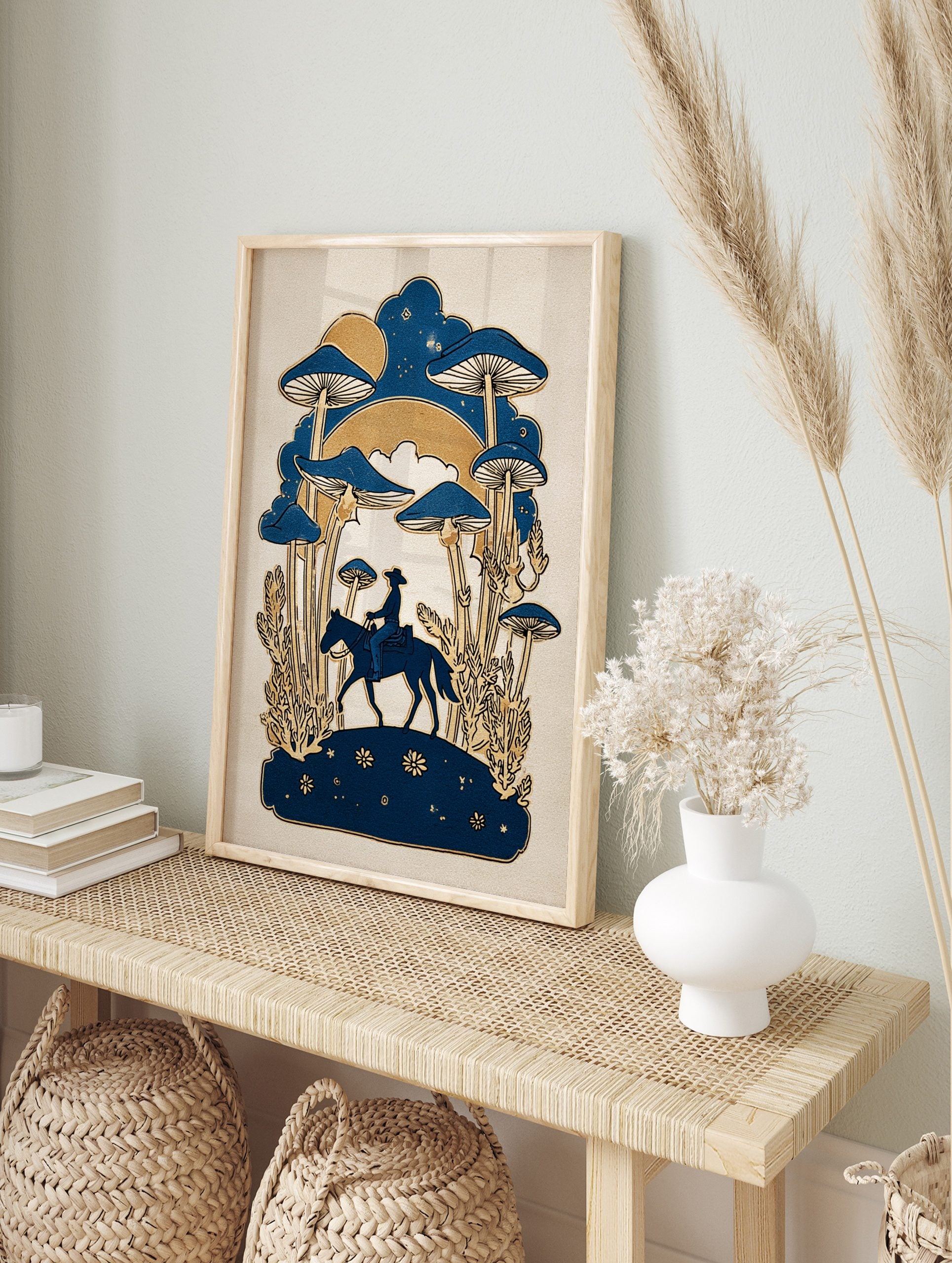 Illustrative print of a cowboy on horseback with giant blue mushrooms and golden plants under, in an alternate framed mockup