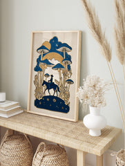 Illustrative print of a cowboy on horseback with giant blue mushrooms and golden plants under, in an alternate framed mockup