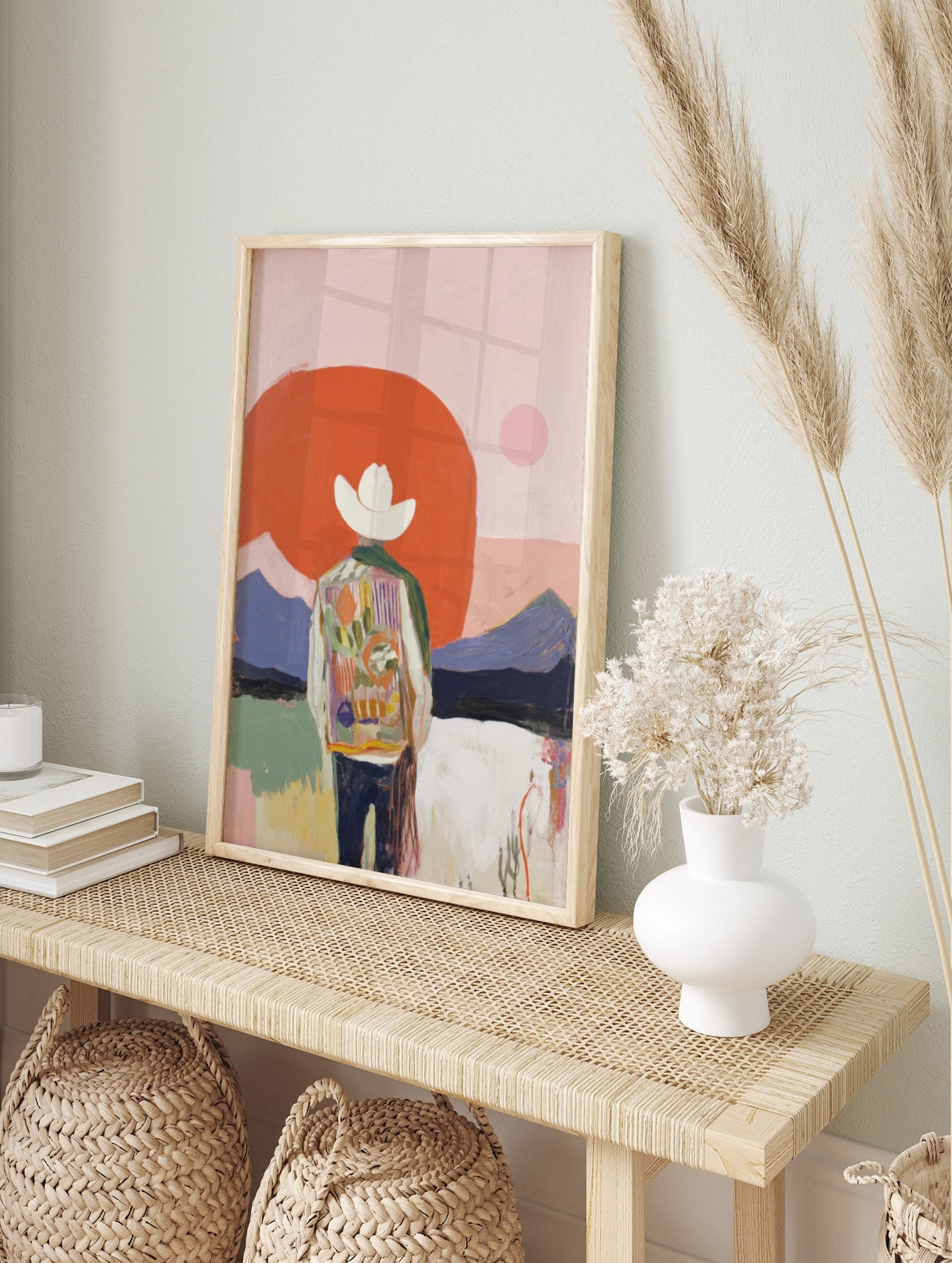 Abstract cowboy art print with figure in colourful jacket, white hat, red sun, and purple, in an alternate framed mockup